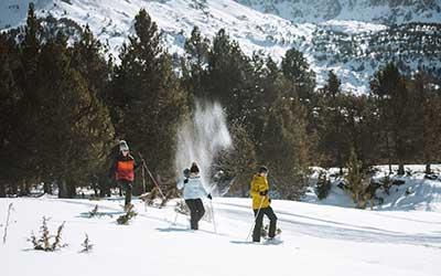 Personas practicando raquetas de nieve en Andorra en el mes de febrero